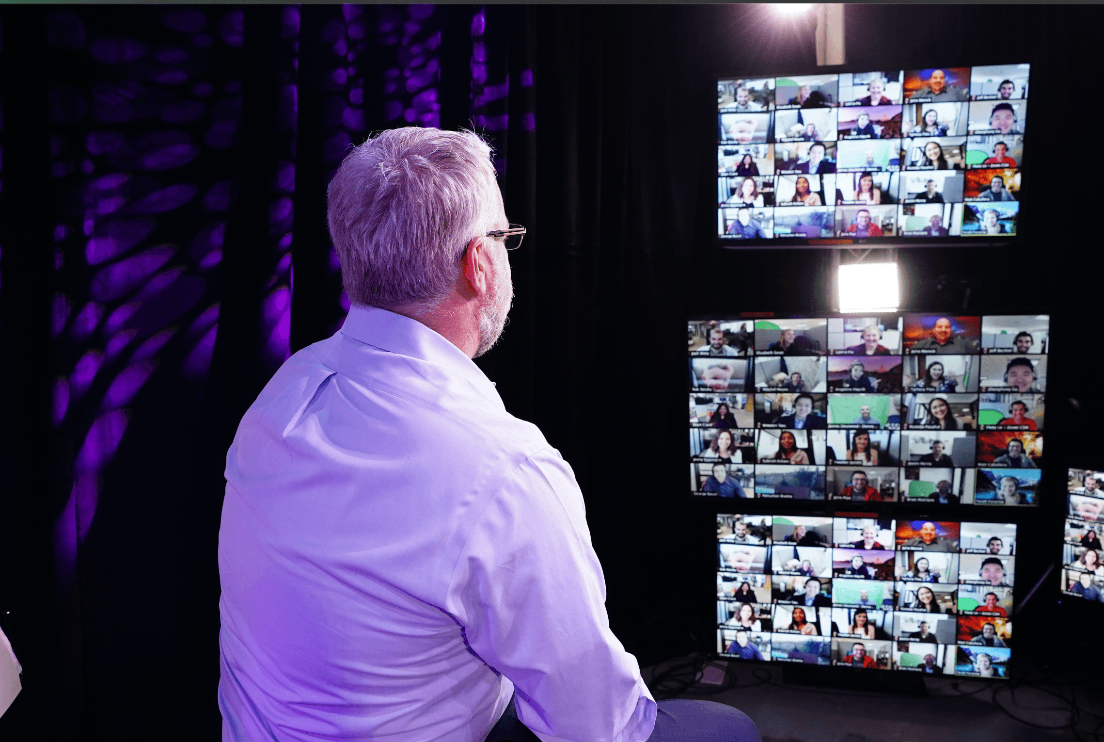 Chris seated on stool engaging with zoom windows